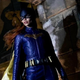 Leslie Grace as Batgirl in a promotional still, standing on a building in Gotham and looking out to the distance.